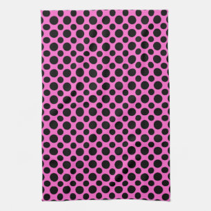 Pois noirs blancs sur serviette de cuisine rose