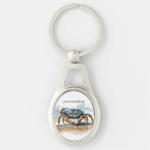 Porte-clés crabe bleu et orange qui se promène sur la plage