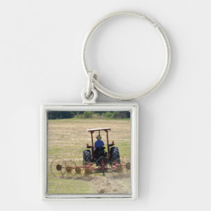 Porte-clés Un jeune garçon conduisant un tracteur récoltant
