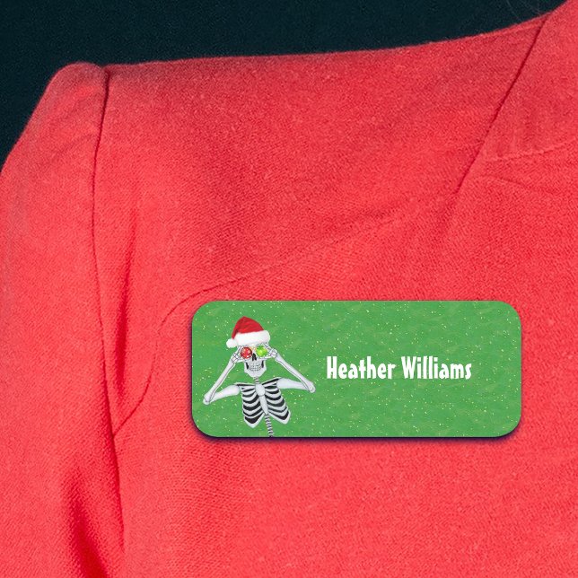Porte-nom Amusants Noël Squelette Ornements Casquette Vert O (Cute Christmas skeleton holding ornaments to eyes on green gold plastic name tag.)