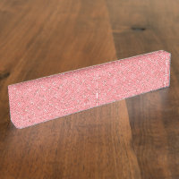 Un tapis aux motifs rouges et roses présente un dé