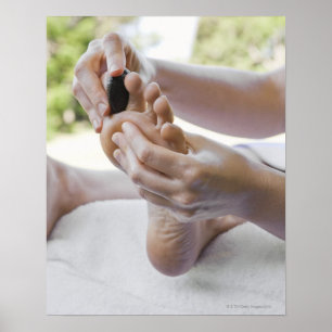 Poster Femme obtenant le massage de pied avec la pierre