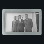 Präsident John Kennedy & Brothers American Camelot Rechteckige Gürtelschnalle<br><div class="desc">Die drei Kennedy-Brüder schlugen sich in der Sonne nieder, als sie unter dem bekannten weißen Portico des Weißen Hauses standen. Präsident John F. Kennedy, der Älteste, lehnte sich an eine Säule, ein wütendes Lächeln, das auf seinen Lippen gespielt wurde. Seine jüngeren Brüder, Robert und Ted, standen neben ihm, ihre Gesichter...</div>
