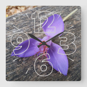 Purple flower on a bench quadratische wanduhr