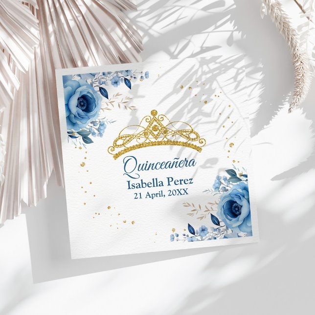 Quinceanera Gold Tiara Glitzer und Blauer Flor Serviette (Quinceanera Gold Tiara Glitter and Blue Floral Napkins on a sunny table with white boho dry flowers)