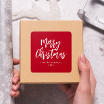 Red and White Brush Script Merry Christmas Quadratischer Aufkleber<br><div class="desc">Modern holiday stickers featuring "Merry Christmas" displayed in white brush script lettering with a red background. Personalize the simple Merry Christmas stickers with your name and year in white lettering. The red Christmas stickers are perfect for sealing holiday envelopes,  party favor bags,  and gifts.</div>