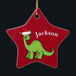 Red Christmas Kids Dinosaurier Santa Star Custom Keramik Ornament<br><div class="desc">Phantastischer grüner Dinosaurier lächelt und sieht sehr niedlich in einem Urlaub roten Weihnachtsmannmütze. Ich mag prähistorische Weihnachtstiere und Geschenke,  die Kinder Liebe. Passen Sie dieses Geschenk mit dem Namen des Empfängers an,  um es noch personalisierter zu machen.</div>