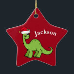 Red Christmas Kids Dinosaurier Santa Star Custom Keramik Ornament<br><div class="desc">Phantastischer grüner Dinosaurier lächelt und sieht sehr niedlich in einem Urlaub roten Weihnachtsmannmütze. Ich mag prähistorische Weihnachtstiere und Geschenke,  die Kinder Liebe. Passen Sie dieses Geschenk mit dem Namen des Empfängers an,  um es noch personalisierter zu machen.</div>