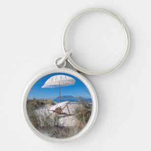 Regenschirm und Stuhl auf Strand Schlüsselanhänger