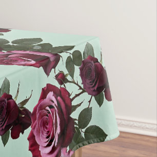 Reiches Lila und tiefrote Rosen auf einem mintgrün Tischdecke