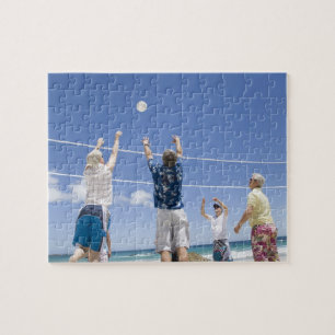 Reife Männer, die am Strand zum Volleyball springe