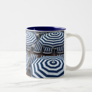 Reihen der gestreiften Strandschirme mit Zweifarbige Tasse