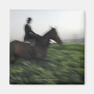 Reiten auf grünem Feld. Reitweibchen Magnet