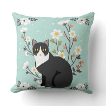 Reizende Tuxedo-Katze im Blumenthrow-Kissen