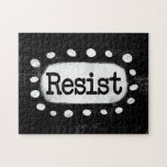 Resist Jigsaw Puzzle<br><div class="desc">Der Text "Resist" wird auf schwarzem Hintergrund zentriert. Der schwarze Text sitzt auf einem weißen Rechteck mit großen,  texturierten weißen Punkten um ihn herum,  was einen spielerischen Kontrast zu der soliden Hintergrund der Farbe bietet.</div>