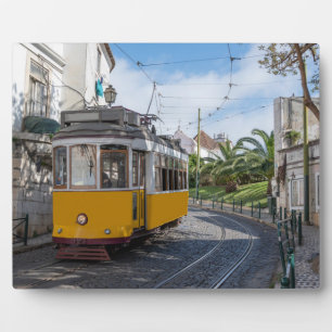 Retrogelbe Straßenbahn auf einer Straße in Lissabo Fotoplatte