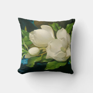 Riesige Magnolien auf einem blauen Samtstoff Kissen