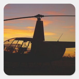 Robinson R44-Hubschrauber bei Sonnenuntergang Quadratischer Aufkleber