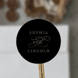 Romantische Goldkalligraphie-Schwarze Umschlag Auf Runder Aufkleber<br><div class="desc">Diese romantischen goldfarbenen Umschlag Aufkleber sind perfekt für eine Hochzeit. Das moderne klassische Design besticht durch extravagante Wirbel und skurrile Schnörkel mit herrlich eleganten, handgezeichneten Imitaten, die auf Champagner-Goldfolie-Typografie setzen. Personalisieren Sie das Etikett mit den Namen der Braut und des Bräutigams. Bitte beachten Sie: Dieses Design enthält keine echte Goldfolie....</div>