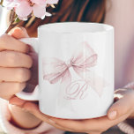 Rosa Bow Kaffeetasse<br><div class="desc">Fügen Sie Ihrer Morgenroutine eine Touch von Eleganz und Weiblichkeit hinzu, mit dieser wunderschönen Tasse mit einem zarten rosa Bogen und einem personalisierten Script-Initialmonogramm. Das weiche, mädchenhafte Design macht es zu einer stilvollen Ergänzung Ihrer Küche, die Ihnen einen niedlichen und trendigen Akzent auf Ihre Kaffee- oder Teezeit bringt. Lassen Sie...</div>