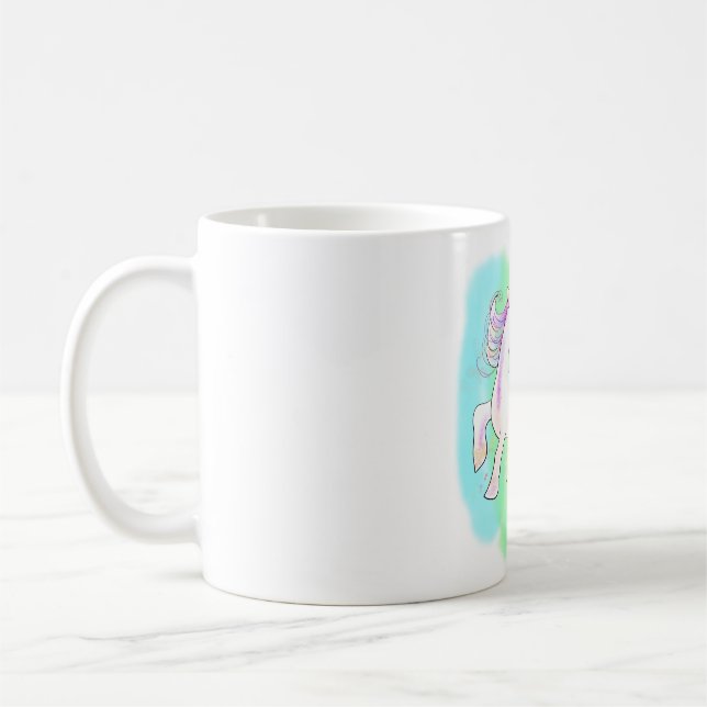 Rosa Einhorn auf dem T - Shirt mit Regenbogenunter Kaffeetasse (Links)