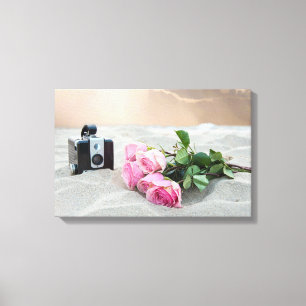 Rosa Rosen in Sand mit Retro-Kamera Leinwanddruck