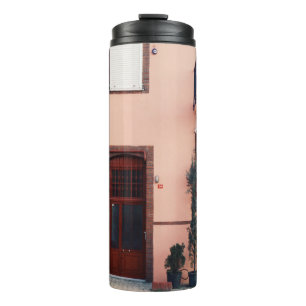 ROSA UND ROTES BETONGEBÄUDE THERMOSBECHER