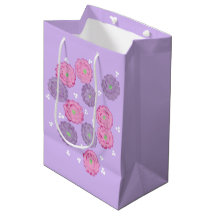 Rosa und violette Blumen auf lila Geschenktüten