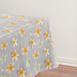 Rosa und weiße Plumeria-Blüten auf Hellgrau Tischdecke