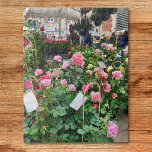 Rose<br><div class="desc">Dieses Rätsel enthält ein Foto eines Verkaufsstandes von rosa Rosen auf einem französischen Markt.</div>