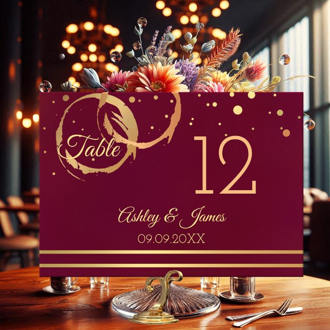 Rose Gold Marsala Weinstöcke Tischnummer Karte (Table number card featuring rose gold and gold wine stain rings with sparkling confetti on burgundy)