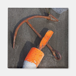 Rostiger Anker und Boje auf einem Strand Magnet