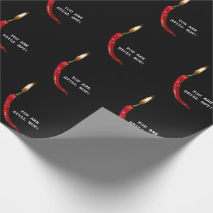 Rote Paprika mit Kerzenflamme auf Schwarz Geschenkpapier