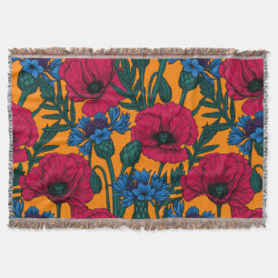 Rote Pfeffer und blaue Kornblumen auf Orange Decke