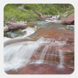 Roter Felsen im Baring Creek im Glacier National Quadratischer Aufkleber
