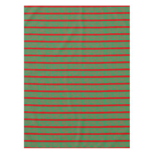 Roter grüner Weihnachtsstrumpf auf grünem Rot Tischdecke