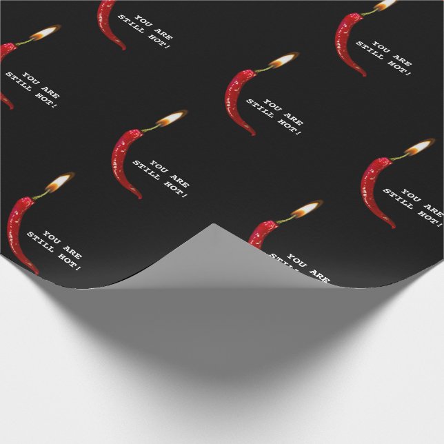 Roter Paprika mit Kerzenentzündung auf schwarz Geschenkpapier (Ecke)