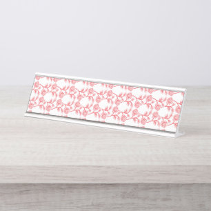 Rotes und rosafarbenes Packpapier mit wiederholend Schreibtischnamensplakette