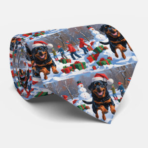 Rottweiler läuft im Schnee mit Weihnachtsmütze Krawatte