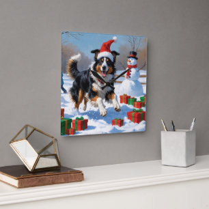 Rough Collie läuft im Schnee mit Weihnachtshut Quadratische Wanduhr