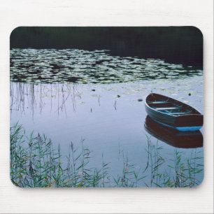 Rowboat auf einem kleinen See umgeben von Wasser Mousepad