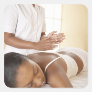 Rückenmassage. Frauen, die eine Rückenmassage von Quadratischer Aufkleber