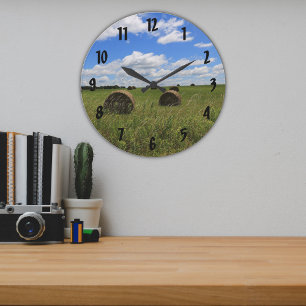 Rundballen auf einem sommerlichen Feld eines Bauer Große Wanduhr