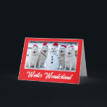Samoyeds und Snowman Karte<br><div class="desc">Vier Samoyte mit Weihnachtsmannmützen posieren stolz mit einem Schneemann, den sie gebaut haben.</div>