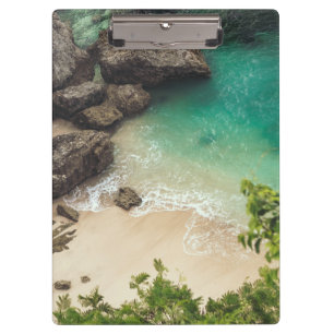 Sandstrand mit grünen Bäumen, Felsen und Ozean Klemmbrett