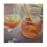Sangria and Sunshine Fliese<br><div class="desc">This image shows a refreshing glass and pitcher of citrus sangria, perfect for a warm day. The fresh slices of lemon and orange add bright colour and hint of natural sweetness. One glass sits ready to enjoy while sangria is being poured from a small glass pitcher beside it, perfect for...</div>
