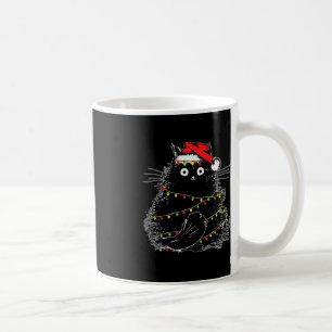 Santa Black Cat hallte in Weihnachtsbaumlicht auf Kaffeetasse