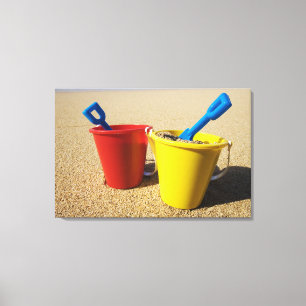 Schaufeln und Eimer auf Sandy-Strand Leinwanddruck
