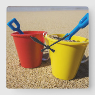 Schaufeln und Eimer auf Sandy-Strand Quadratische Wanduhr