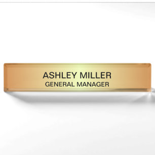 Schild mit goldenem Hintergrund und schwarzem Text Namensplakette
